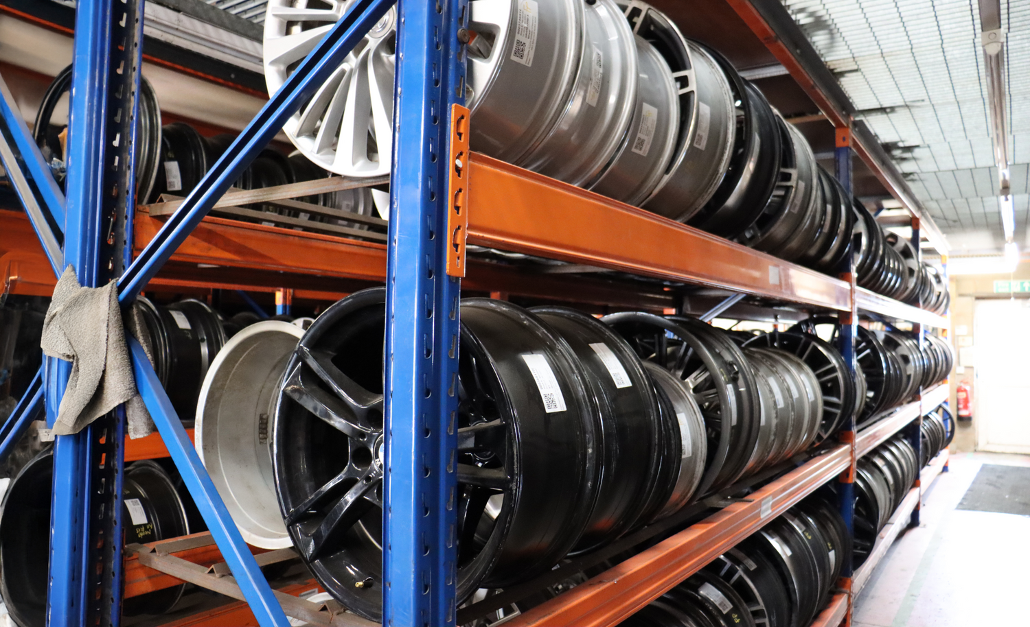 Shelves stocked with various car wheels in a warehouse setting